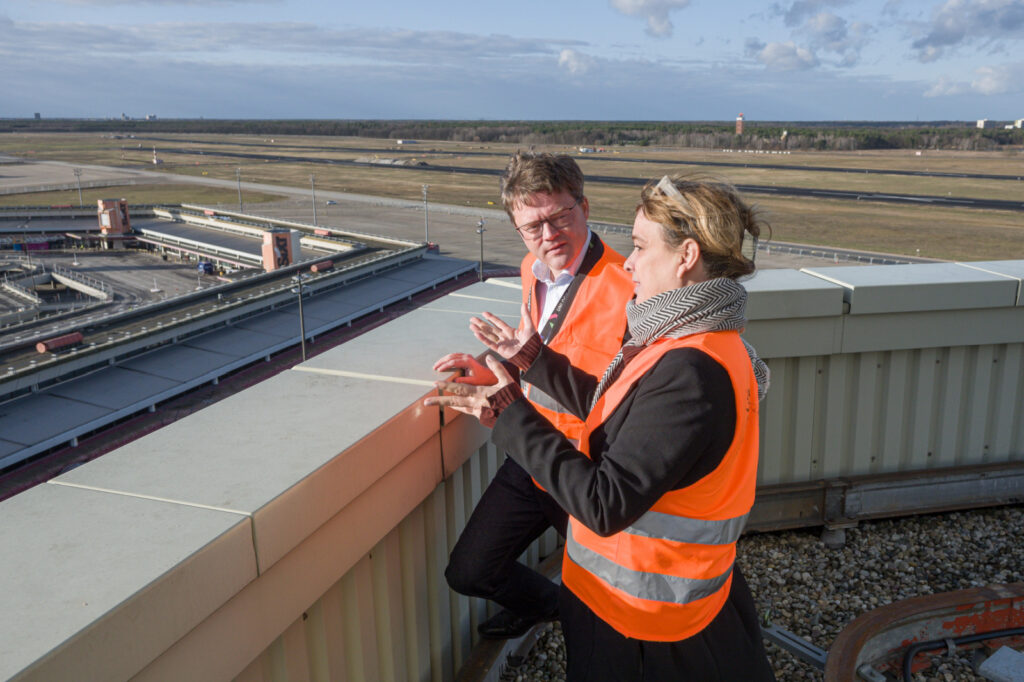 Gudrun Sack, Geschäftsführerin der Tegel Projekt GmbH, erläutert Dr. Sören Trebst, Vorsitzender der Geschäftsführung von 1&1 Versatel, die ersten Bauabschnitte im westlichen Bereich des ehemaligen Flughafens.