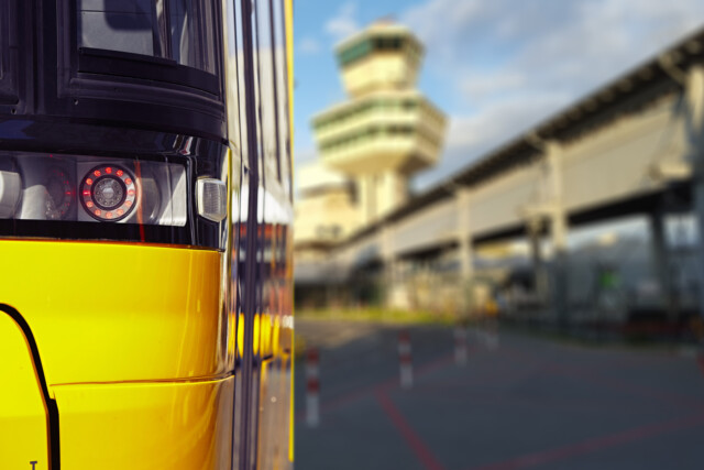 Straßenbahn im Vordergrund. Verschwommen im Hintergrund der Tower des ehemaligen Flughafens Berlin TXL.